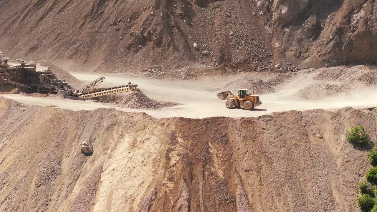 Detail view of a mining bulldozer dumping tailings into a cliff at a limestone mine in northern Argentina, Jujuy Province, lithium tringulum