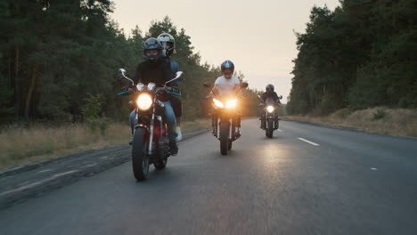 bikers ride on the road among the pine forest 1