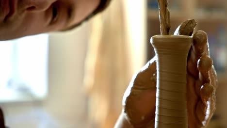 potter shaping a clay vessel