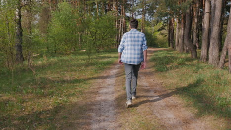 man walking through a forest path