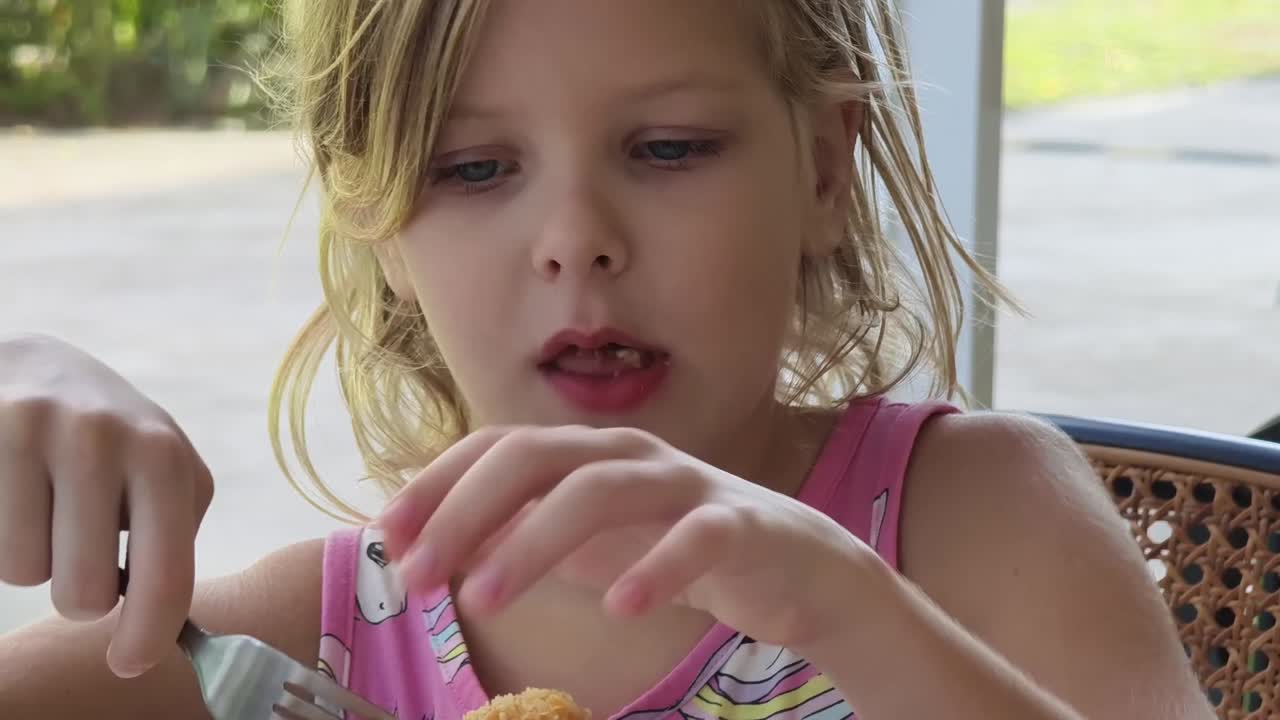 Ragazza che mangia pollo fritto