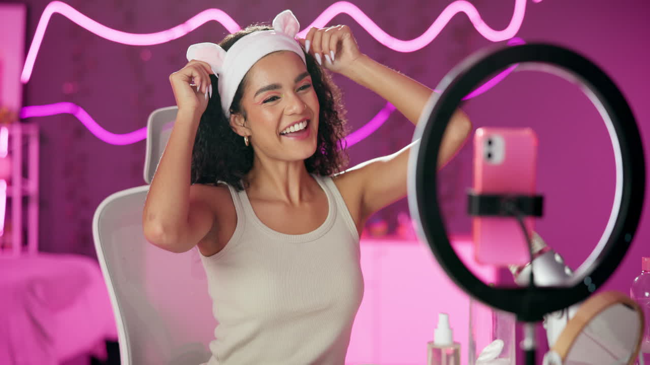 Woman with bunny ears headband vlogging with ring light