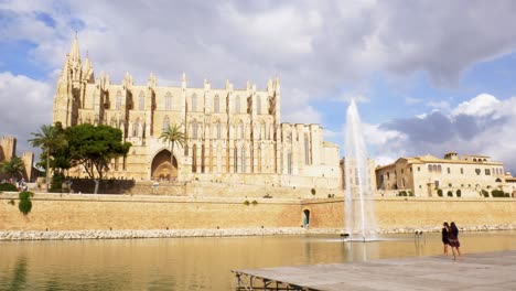 Two-people-prepairing-for-a-photo-shoot-infront-of-a-fountain-and-a-cathedral