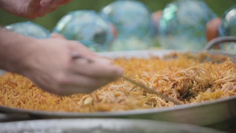 person serving paella from a pan