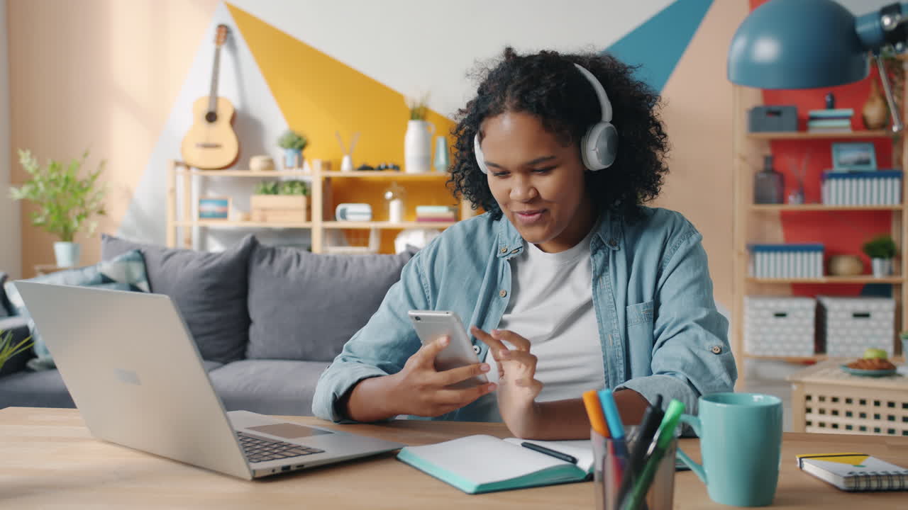 Woman working from home on laptop and smartphone
