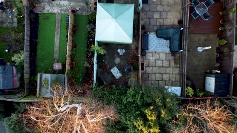 un dron ascendiendo, despegando hacia una vista general de un barrio suburbano, alguien está practicando el vuelo de un dron en el jardín