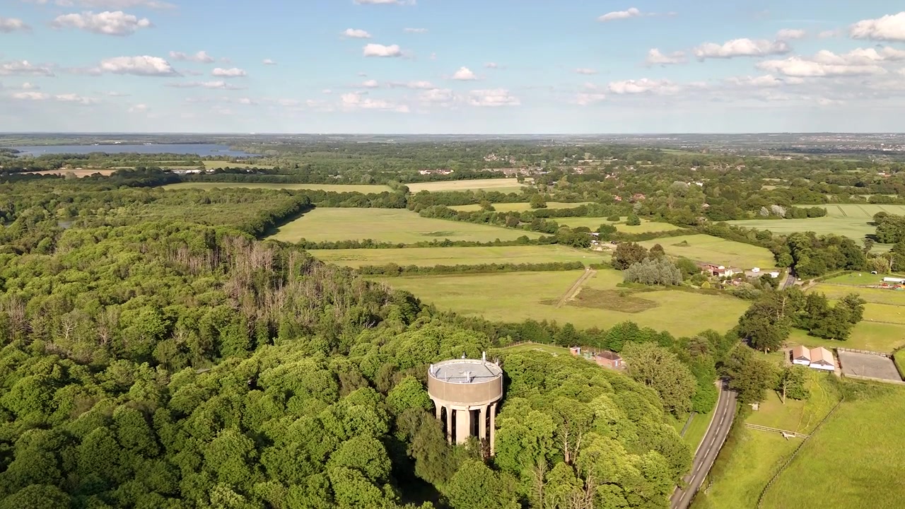 Scena rurale con una torre dell'acqua vicino a villaggi nell'Essex, Regno Unito. Ripresa aerea con drone