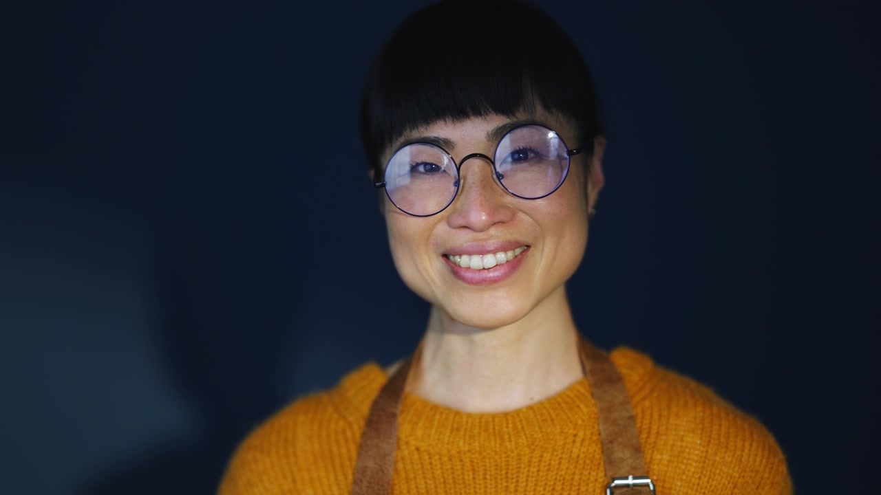 Portrait of a Smiling Woman Wearing Glasses and an Apron