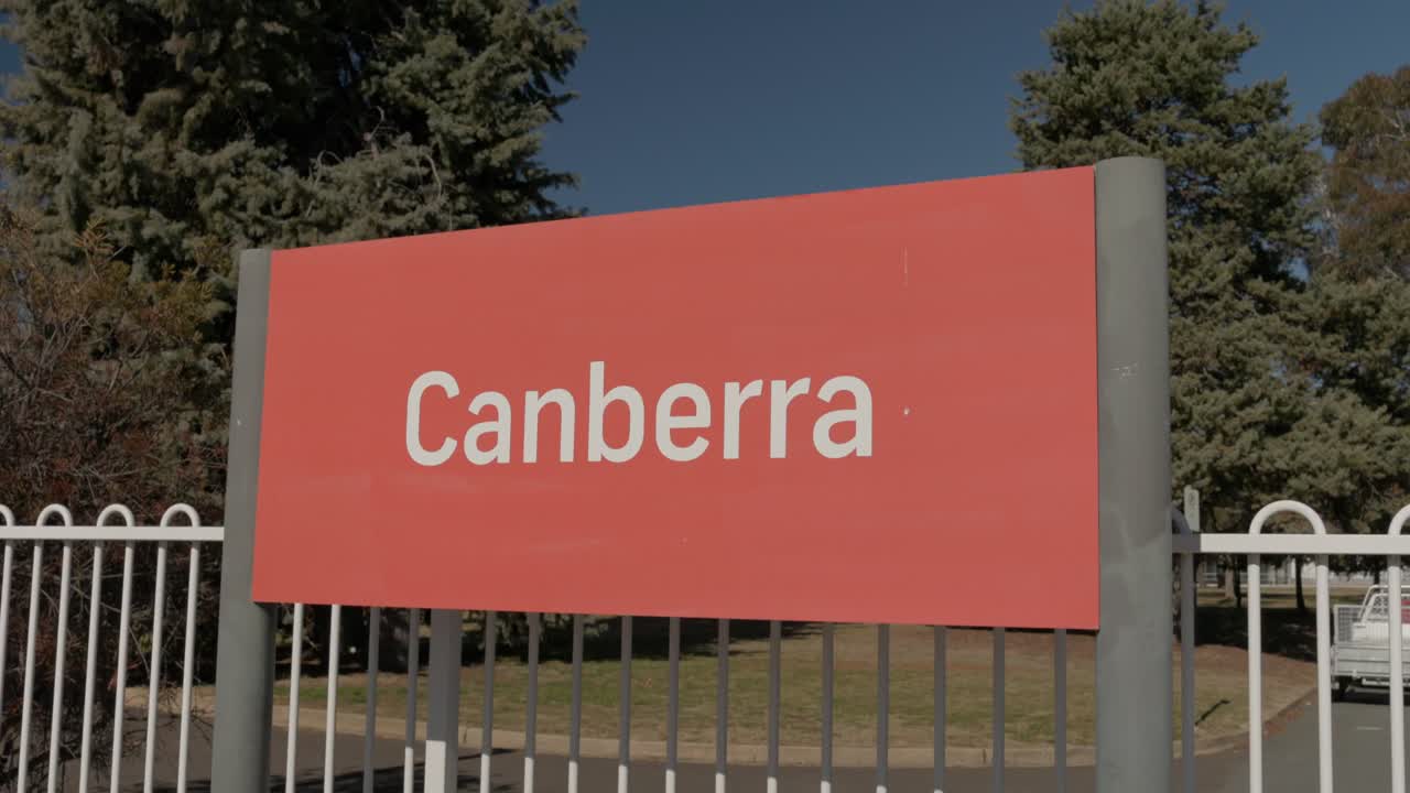 Slow motion footage of the Canberra train station sign with a moody afternoon sky