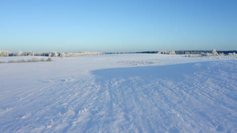 flying over a vast snowy field in the countryside