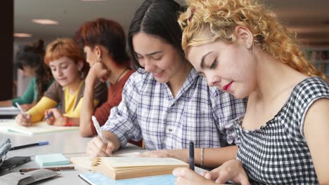 giovani donne che lavorano a un progetto in biblioteca