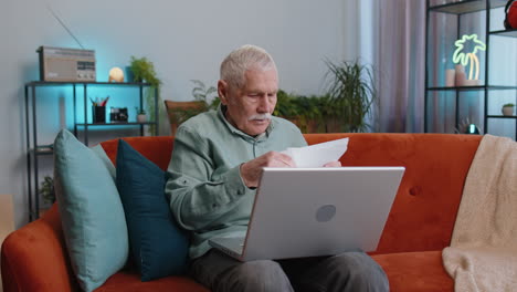 stressed senior man looking at unpaid bank debt loan, doing paperwork, planning budget, throws bills