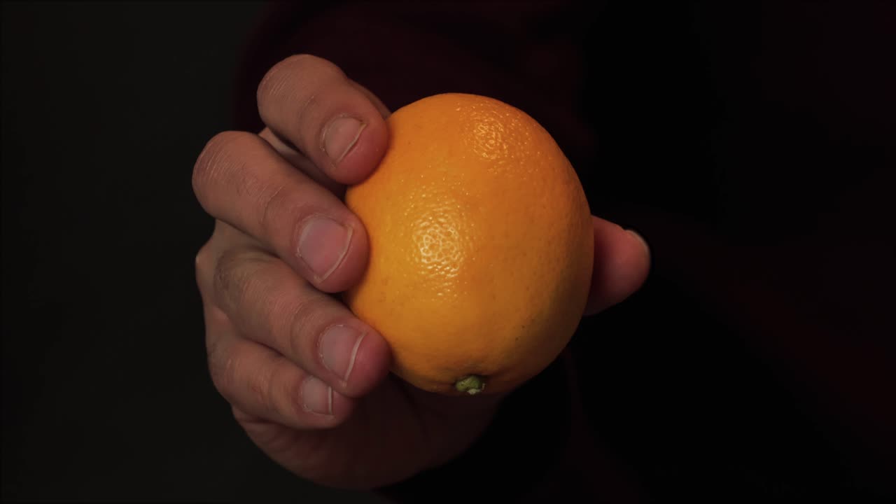 Hand holding a fresh, ripe lemon, highlighting its smooth texture and vibrant color for healthy eating