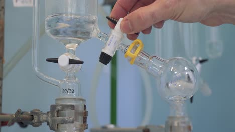 válvula de ajuste científico durante el experimento, líquido giratorio en vidrio