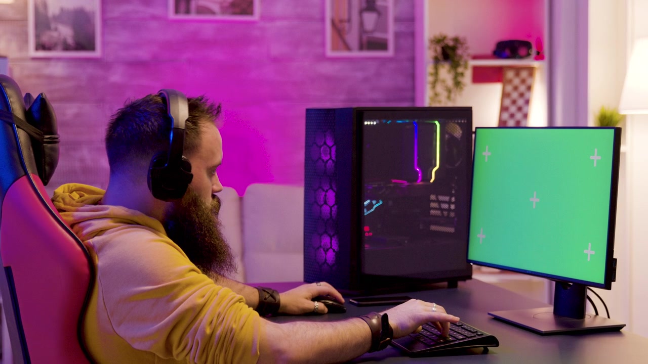 Green screen monitor defines a bearded gamer's desktop room