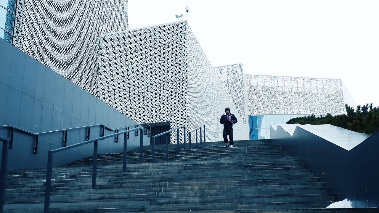 persona subiendo las escaleras frente a un edificio moderno en invierno