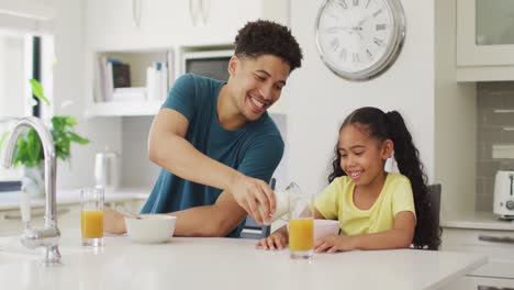 Happy-biracial-father-and-daughter-eating-breakfast-together