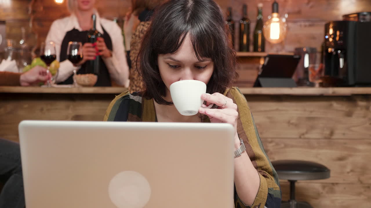 mujer trabajando en una computadora portátil en un café