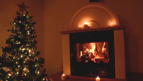 beautiful christmas tree with silvery decoration and soft white lights near a peaceful fireplace with candles