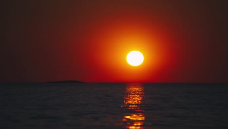 cinemagraph bucle de video sin problemas de una puesta de sol roja vibrante en una remota playa de arena costera de la toscana natural en italia con un cielo dramático y vistas panorámicas al mar. agua azul y turquesa en el pintoresco lugar de vacaciones turísticas de la naturaleza.