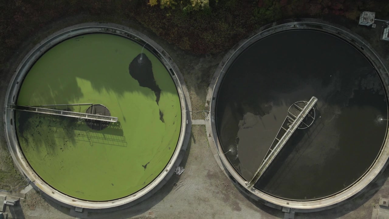 Twin tanks processing wastewater at Drogheda water treatment plant in Ireland, aerial view