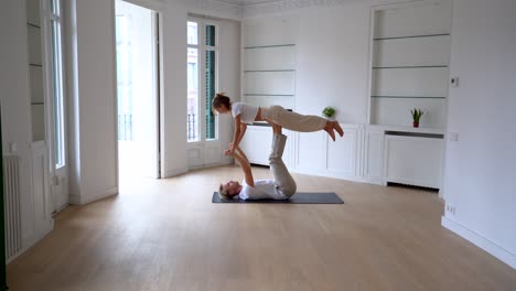 couple practicing acro yoga together at home