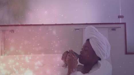 Animation-of-light-spots-over-african-american-woman-taking-bath