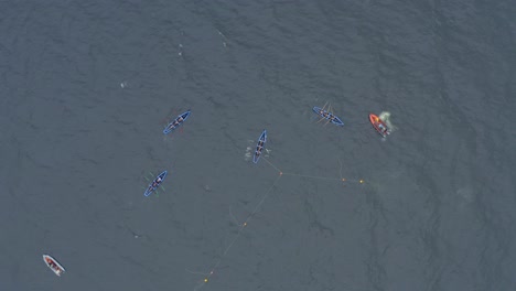 Drone-overview-of-currach-boats-racing-and-turning-around-buoys-in-open-ocean