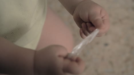 baby playing with plastic package