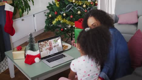 Happy-african-american-mother-and-daughter-on-video-call-on-laptop-with-senior-female-at-christmas