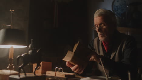 old passionate man read a book in his office at night