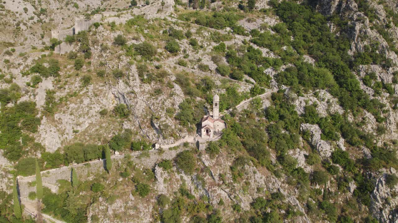 Aerial: Church of Our Lady of Remedy in Kotor, Montenegro's rugged terrain