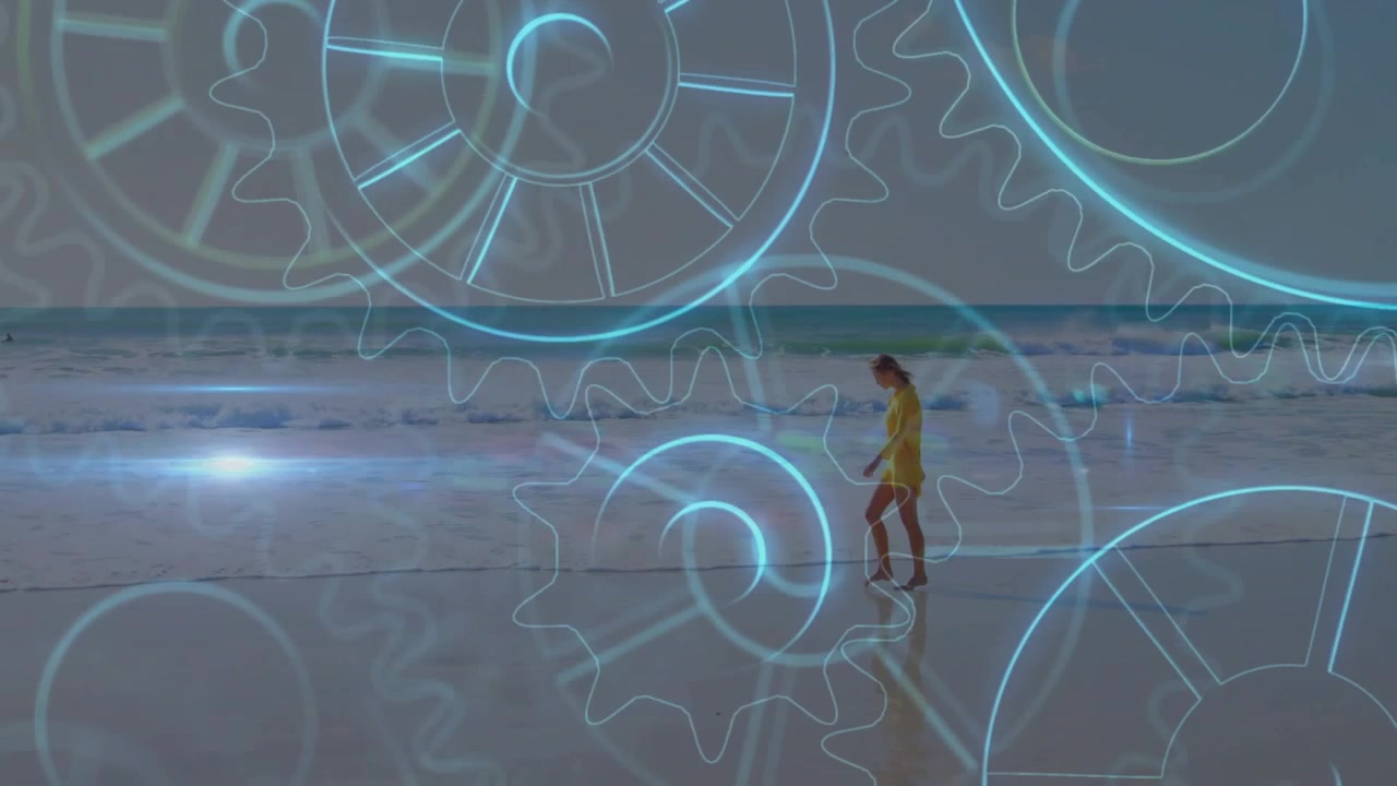 Woman walking along shore in yellow dress, stepping into surf leaving prints, blue gear overlaying