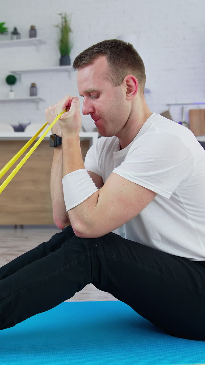 Handsome athletic man doing exercise in home. Indoor training on quarantine. Vertical video