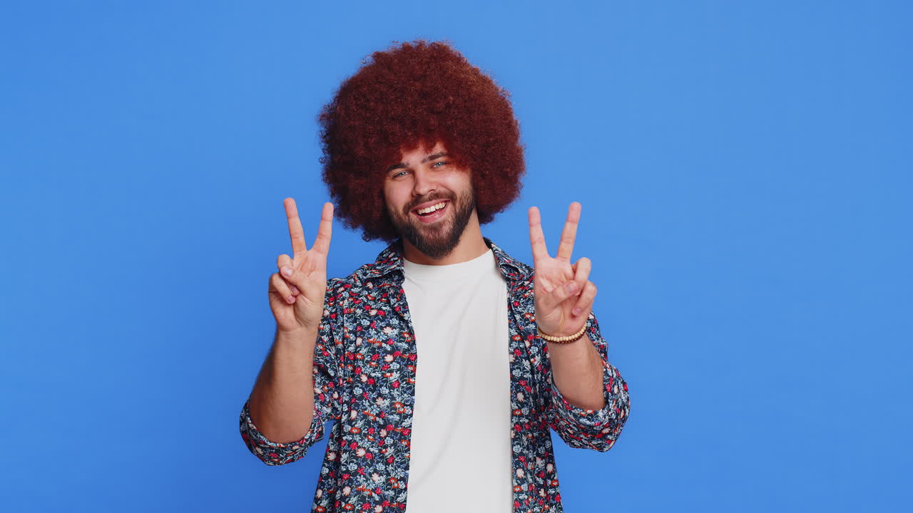 Happy smiling caucasian man showing victory sign hoping for success and win doing peace gesture