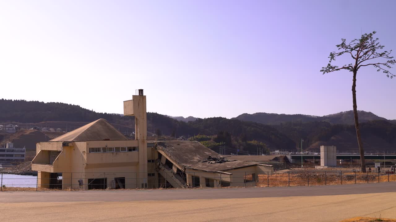 amplia vista del edificio destruido por el tsunami y el pino milagroso en un día despejado