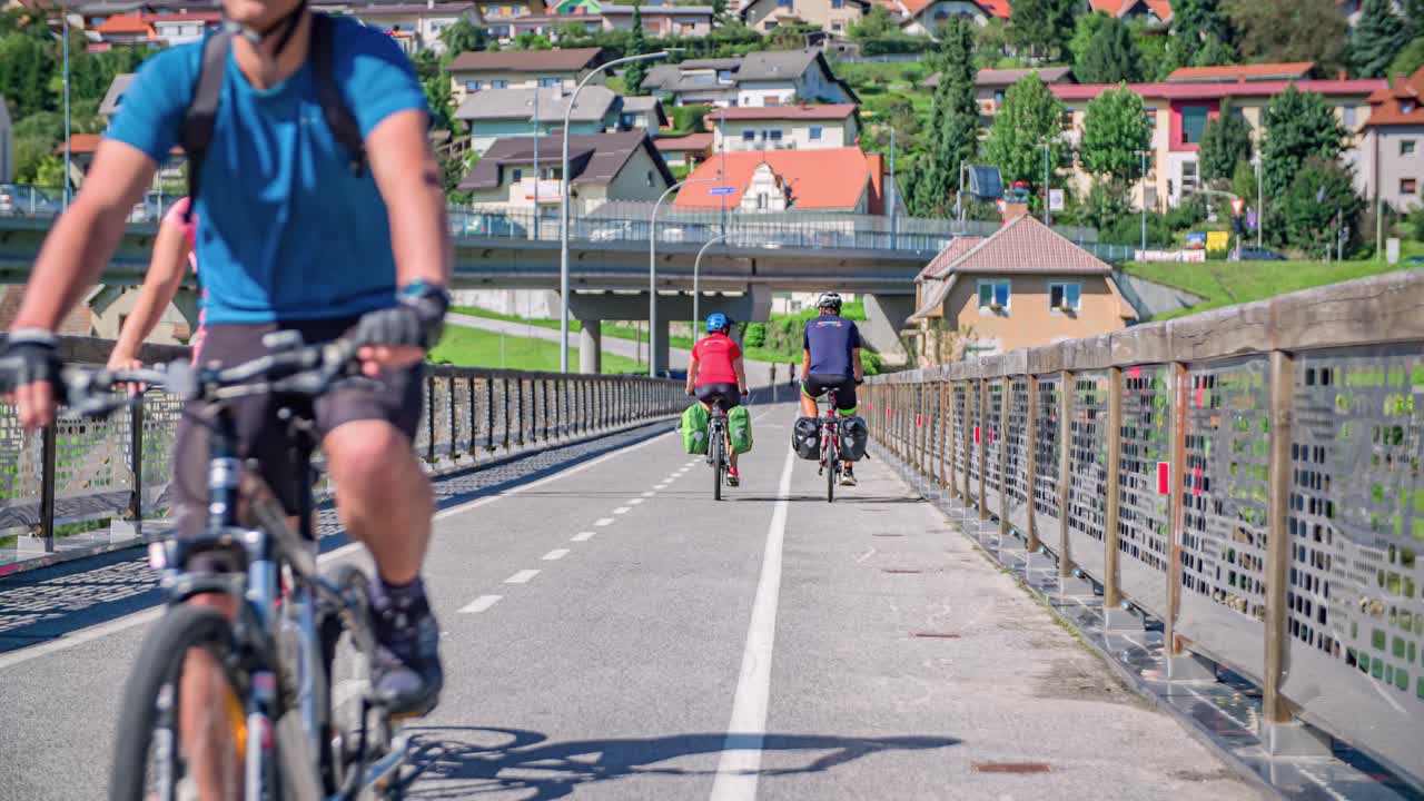 Handheld shot of two couples of bikers riding on both directions over a bridge and saluting each other
