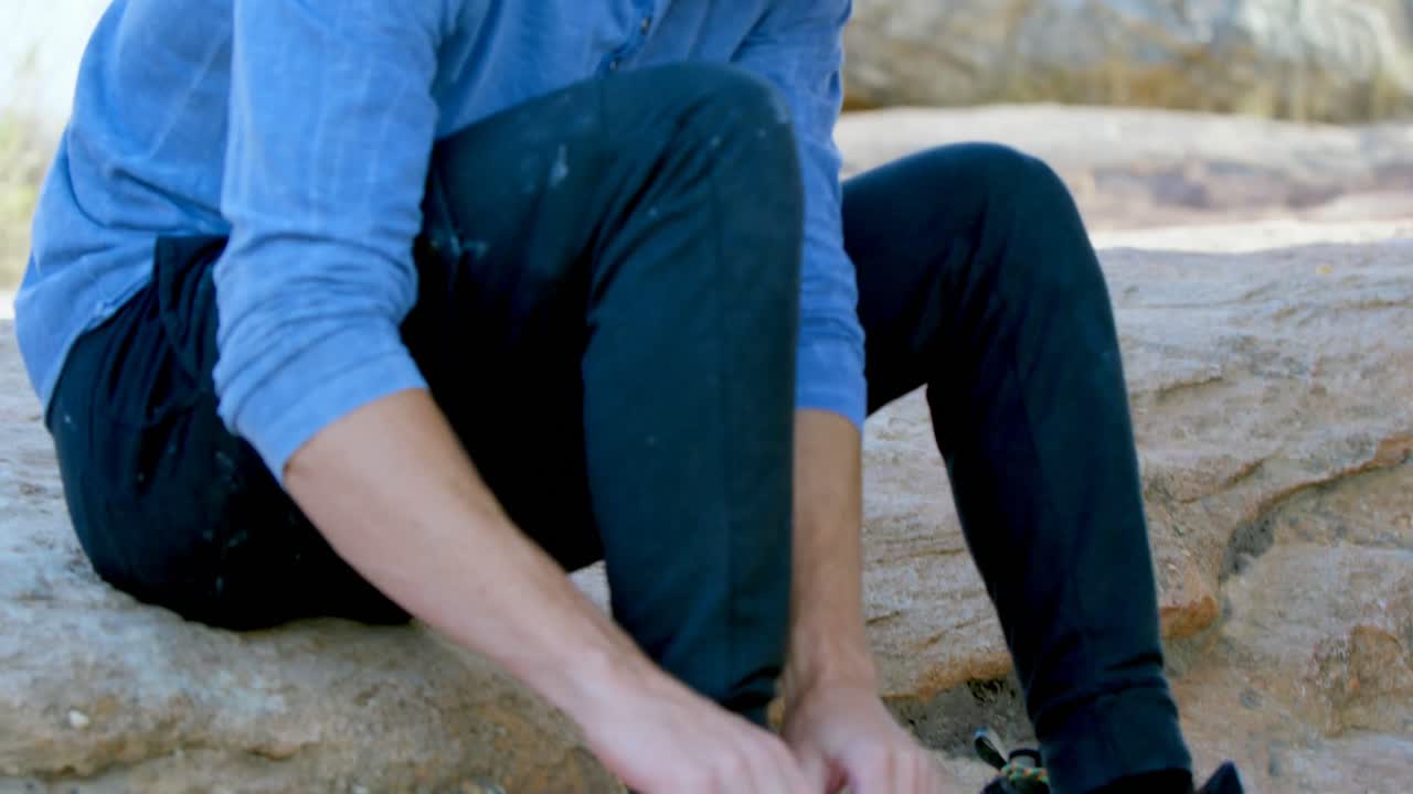 Male hiker wearing his shoes 4k