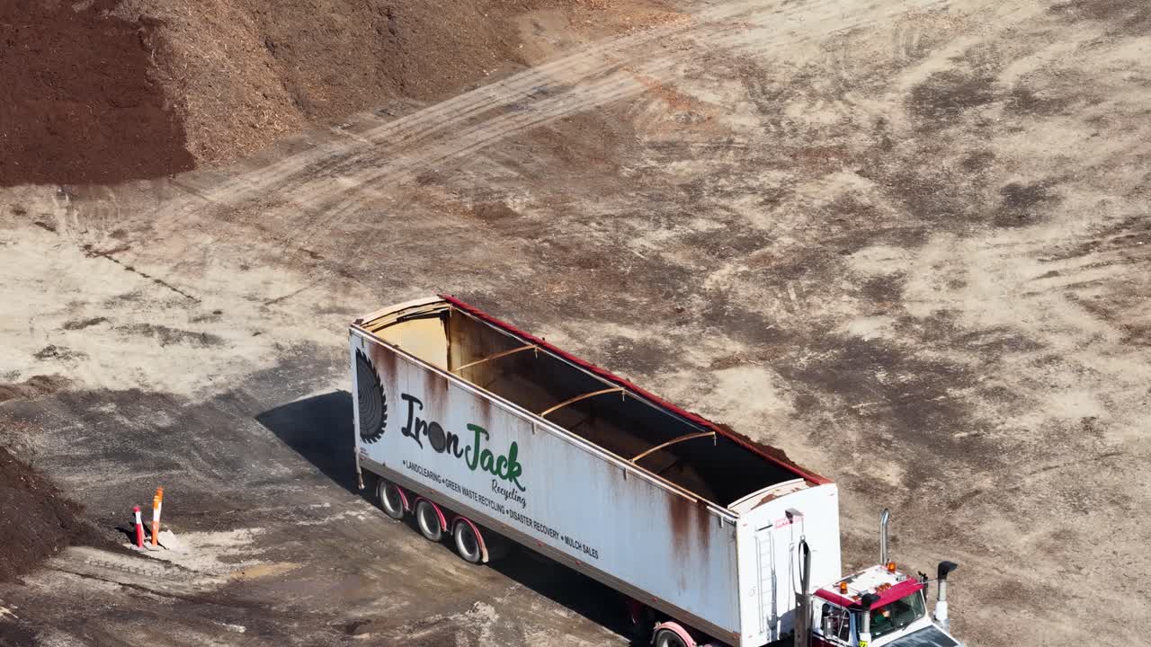 Aerial footage of a truck unloading at a quarry, showcasing industrial operations under bright daylight