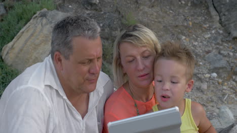 boy and his grandparents with tablet