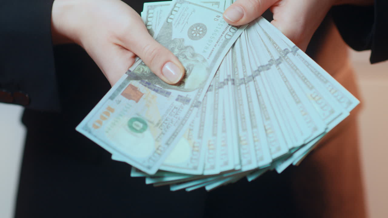 una mujer de negocios caucásica muestra un ventilador de efectivo de papel