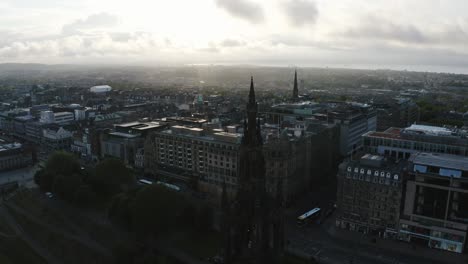 Toma-Aérea-Del-Monumento-Tall-Scott-Y-Todo-El-Centro-De-Edimburgo,-Escocia-Durante-Un-Brillante-Amanecer