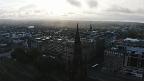 aerial shot of the tall scott monument and all of downtown edinburgh, scotland during a bright sunrise