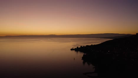 Flying-along-the-shore-of-Lake-Léman-above-Cully,-Lavaux---Switzerland-Beautiful-sunset-colors