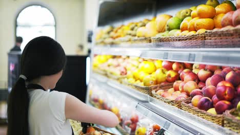 Asian-girl-worker-puts-goods-on-the-shelf.-Filling-shelves-with-goods