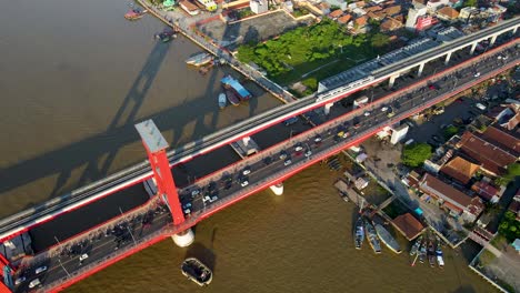 Massive-traffic-of-motorbikes-and-vehicles-over-Ampera-bridge,-aerial-drone-view