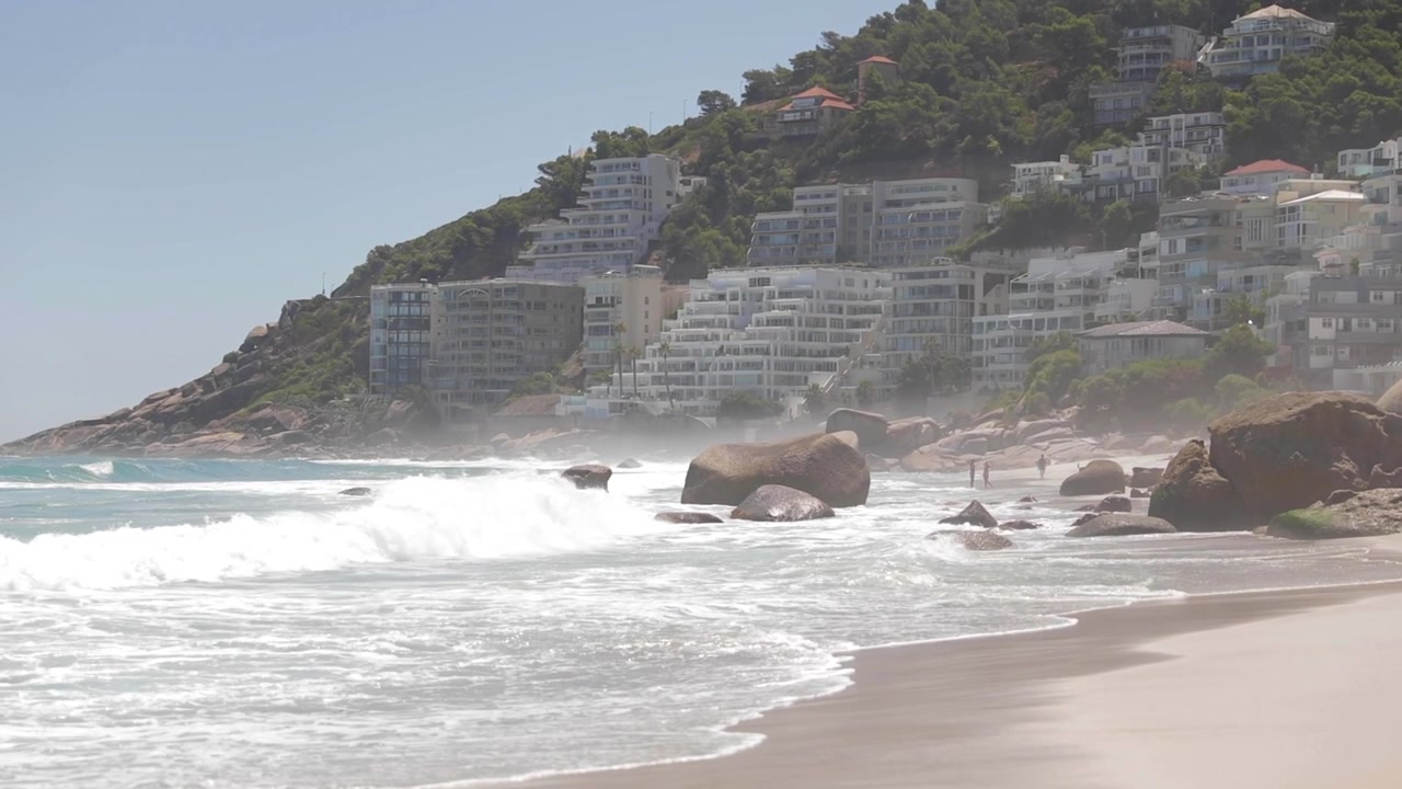 Onde che si infrangono sulla spiaggia a Città del Capo, Sudafrica