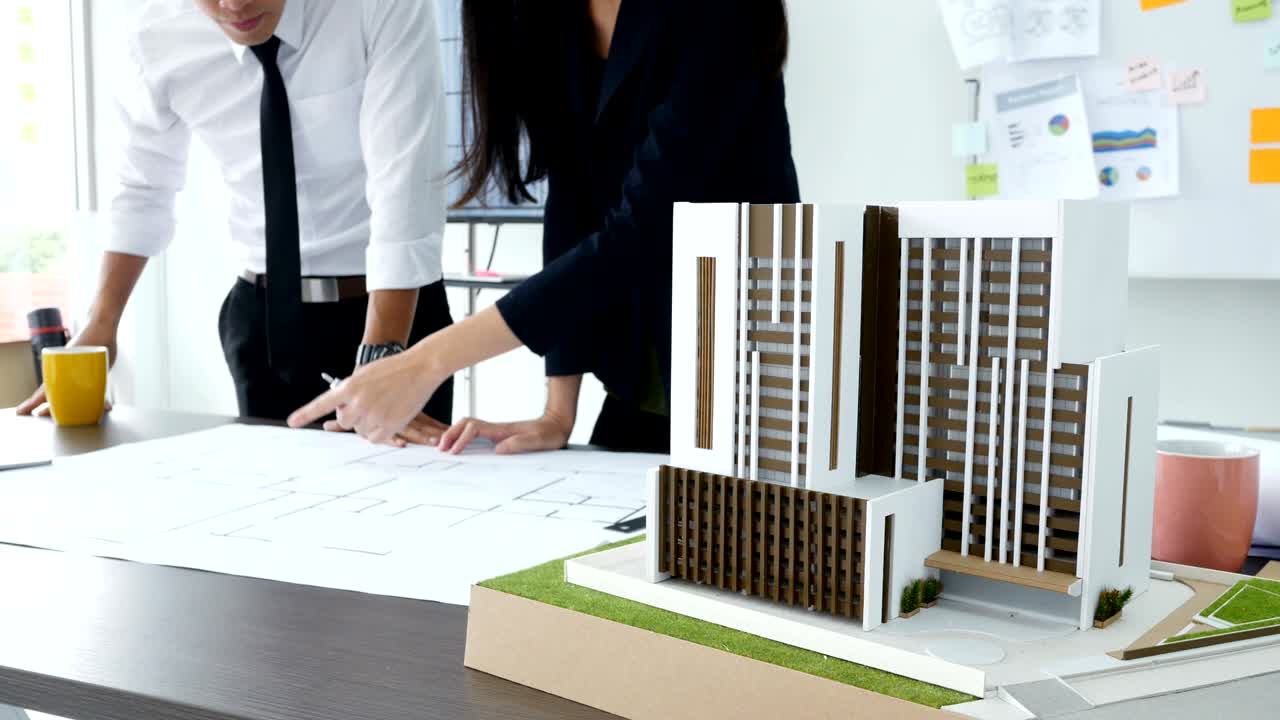 건축가와 건축 프로젝트에 대해 이야기하는 클로즈업: 건축가 또는 엔지니어가 새로운 건축 프로젝트 개발을 조사하는 동안 집중하고 있습니다.