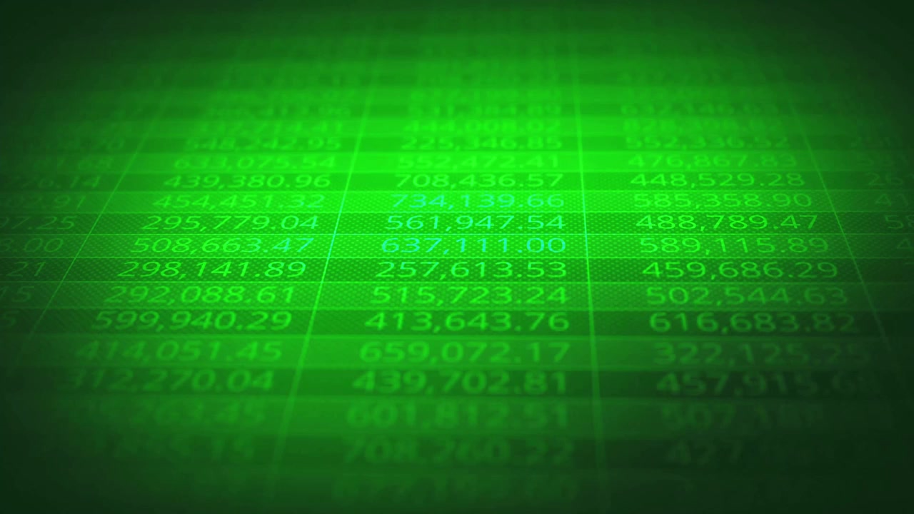 A moving shot of a green grid with random numbers on a dark blue background with a shallow depth of field.