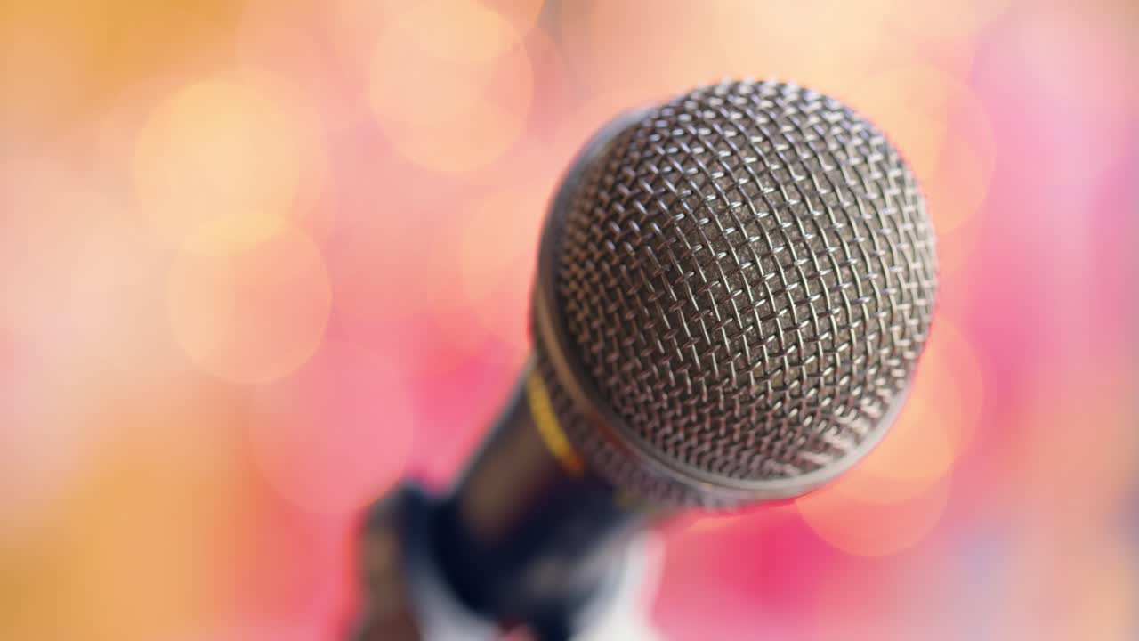 Microphone on stage against a blurry light ,blurry background.